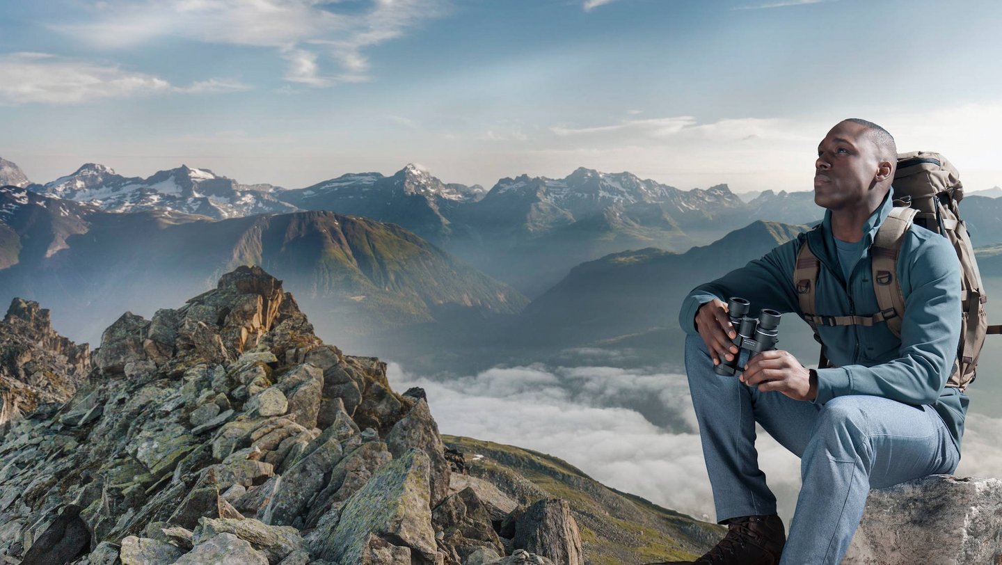 Das Foto zeigt einen Mann mit einem Fernglas in der Hand.