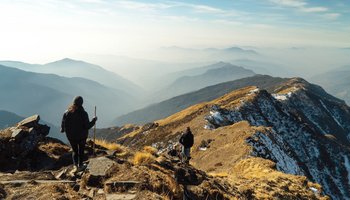 Das Bild zeigt zwei Menschen, welche auf einem Berg wandern.