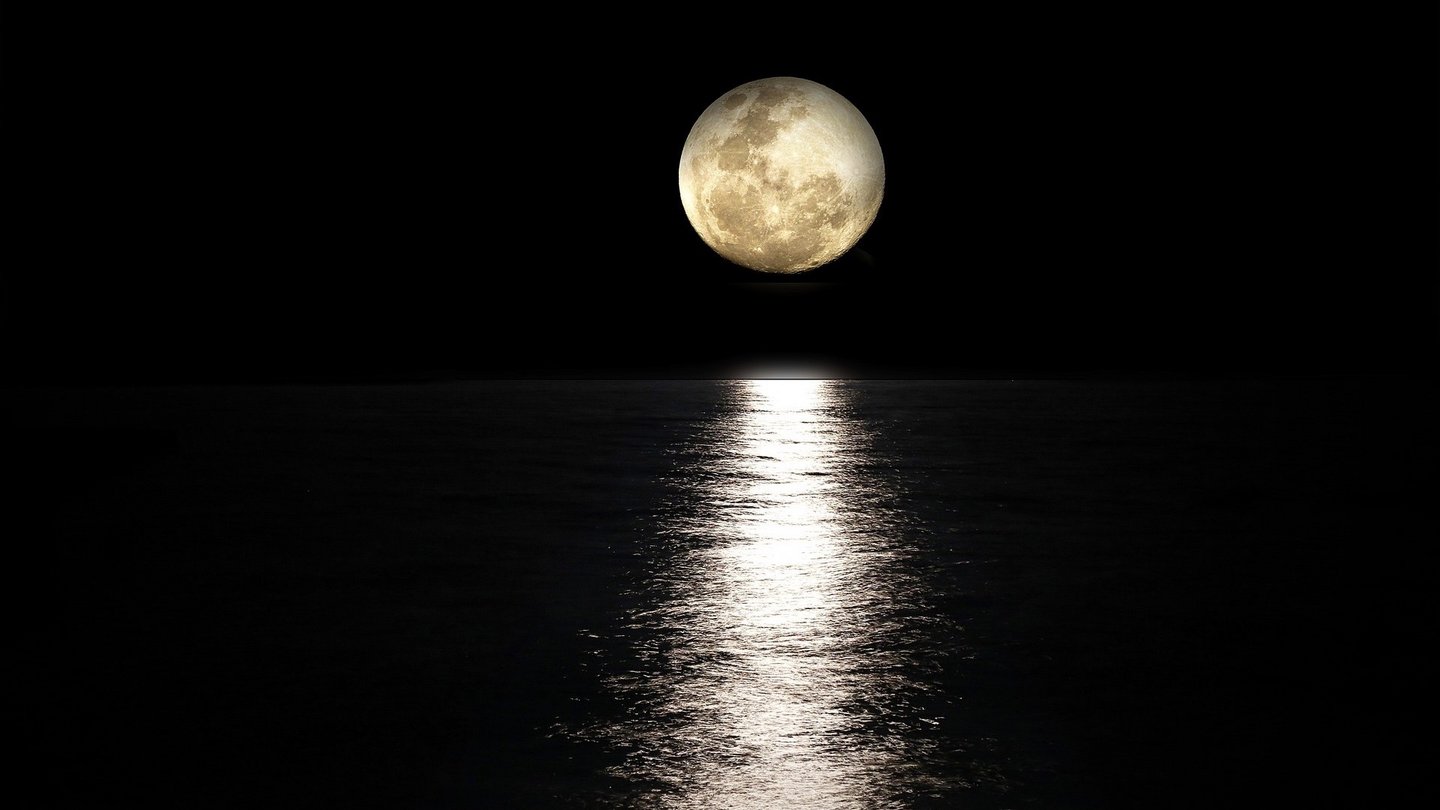 Ein strahlender Vollmond hängt groß am nächtlichen Himmel und spiegelt sich auf der Oberfläche des dunklen Wassers.