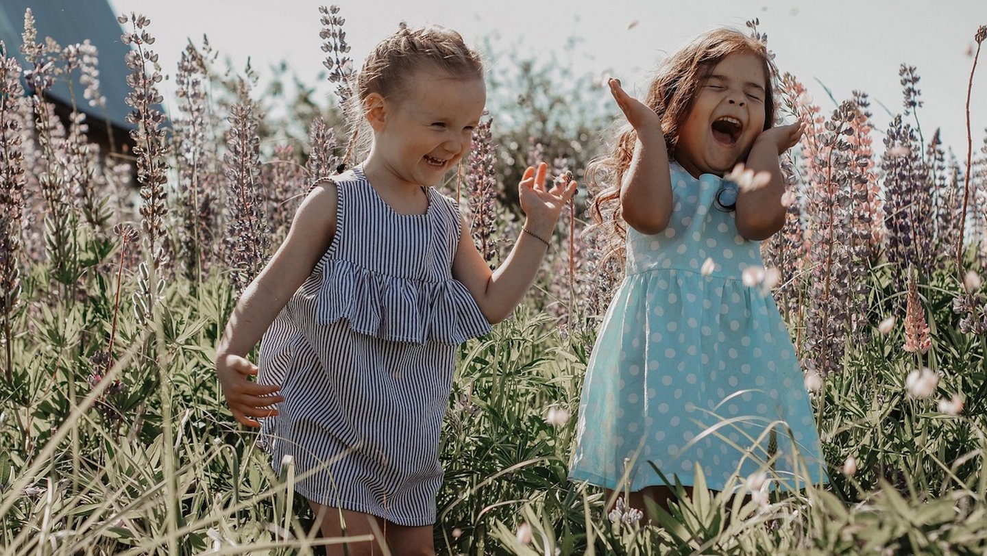 Das Bild zeigt zwei Mädchen in einem Feld.