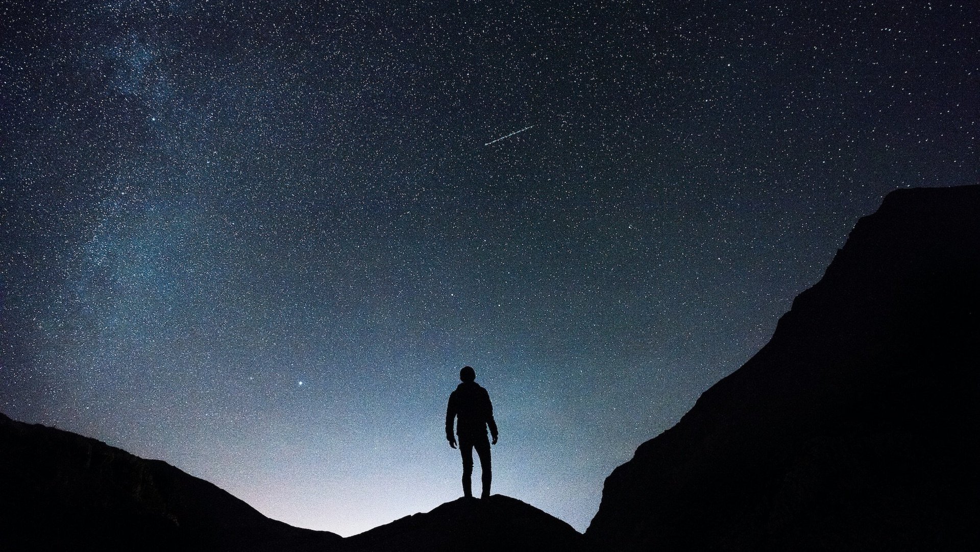 Foto einer Person unter dem Sternenhimmel.