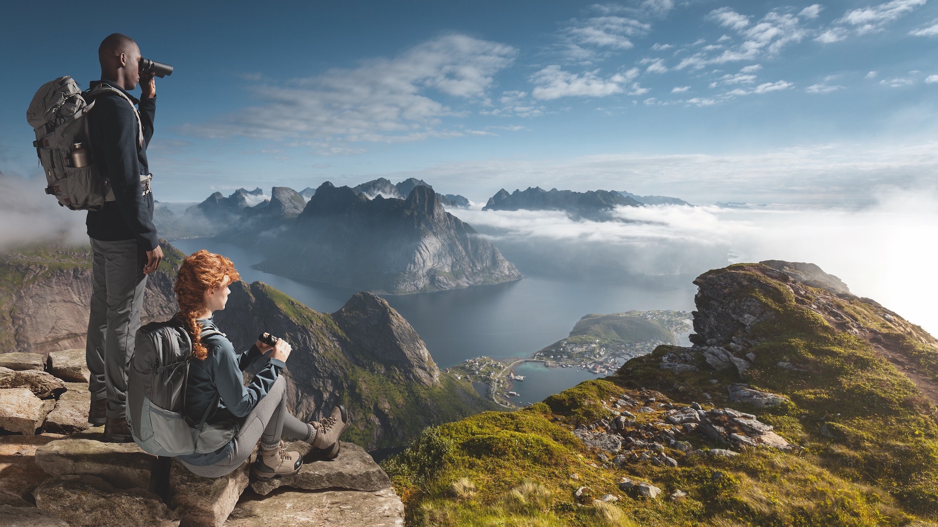 Das Foto zeigt zwei Personen, die auf einem Berg stehen und mit dem Fernglas adventure D die Landschaft bewundern.